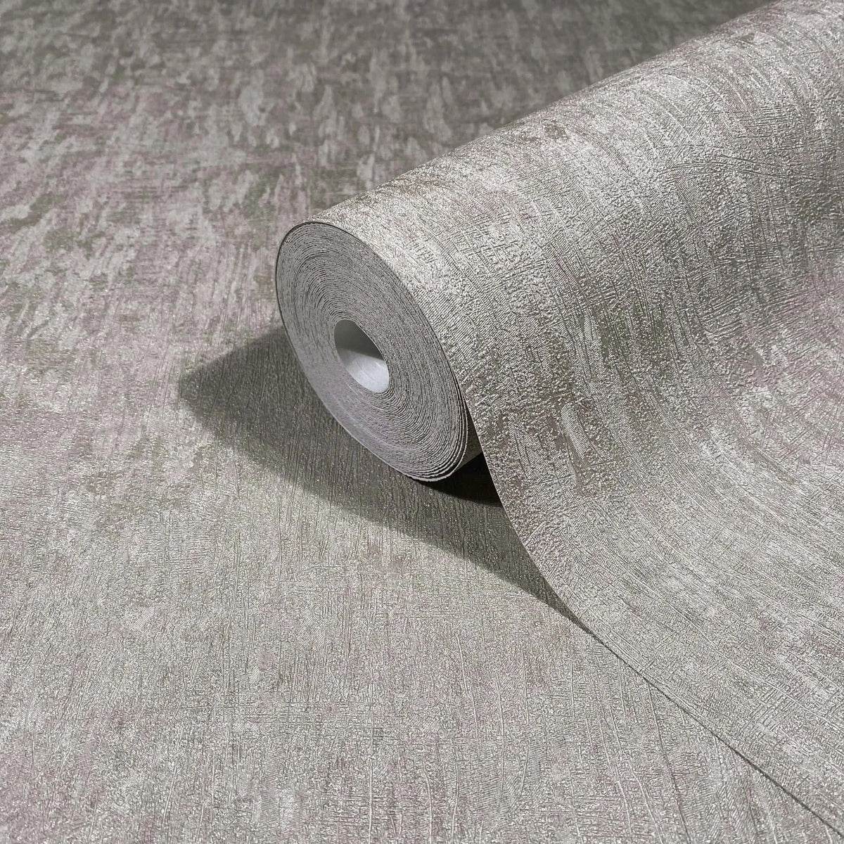 Marburg Ritus 35525 Close-up of a gray textured wallpaper roll partially unrolled on a matching sheet, showing an irregular abstract pattern.