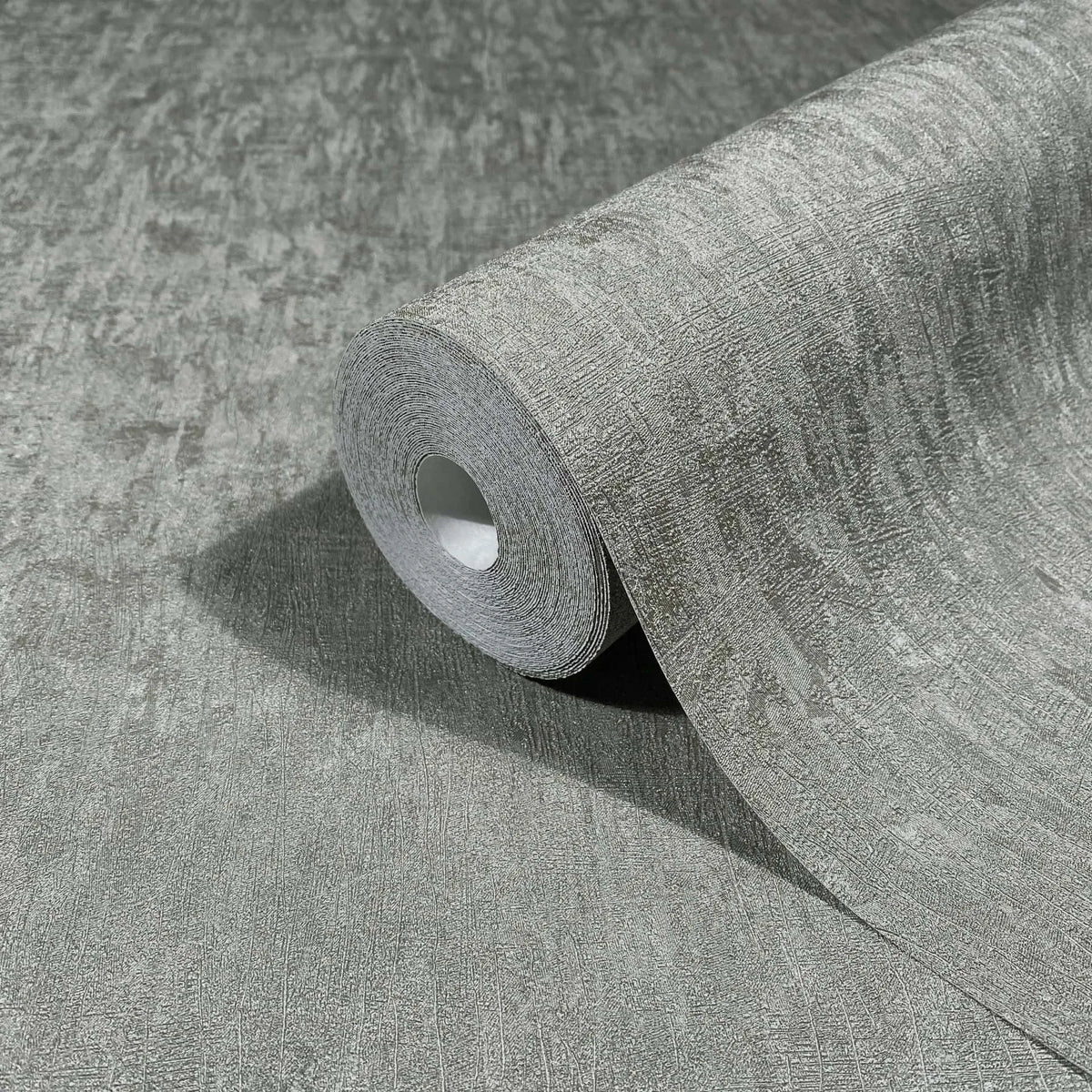 Marburg Ritus 35528 A gray textured wallpaper roll partially unrolled on a matching surface, showing a subtle irregular linear pattern.