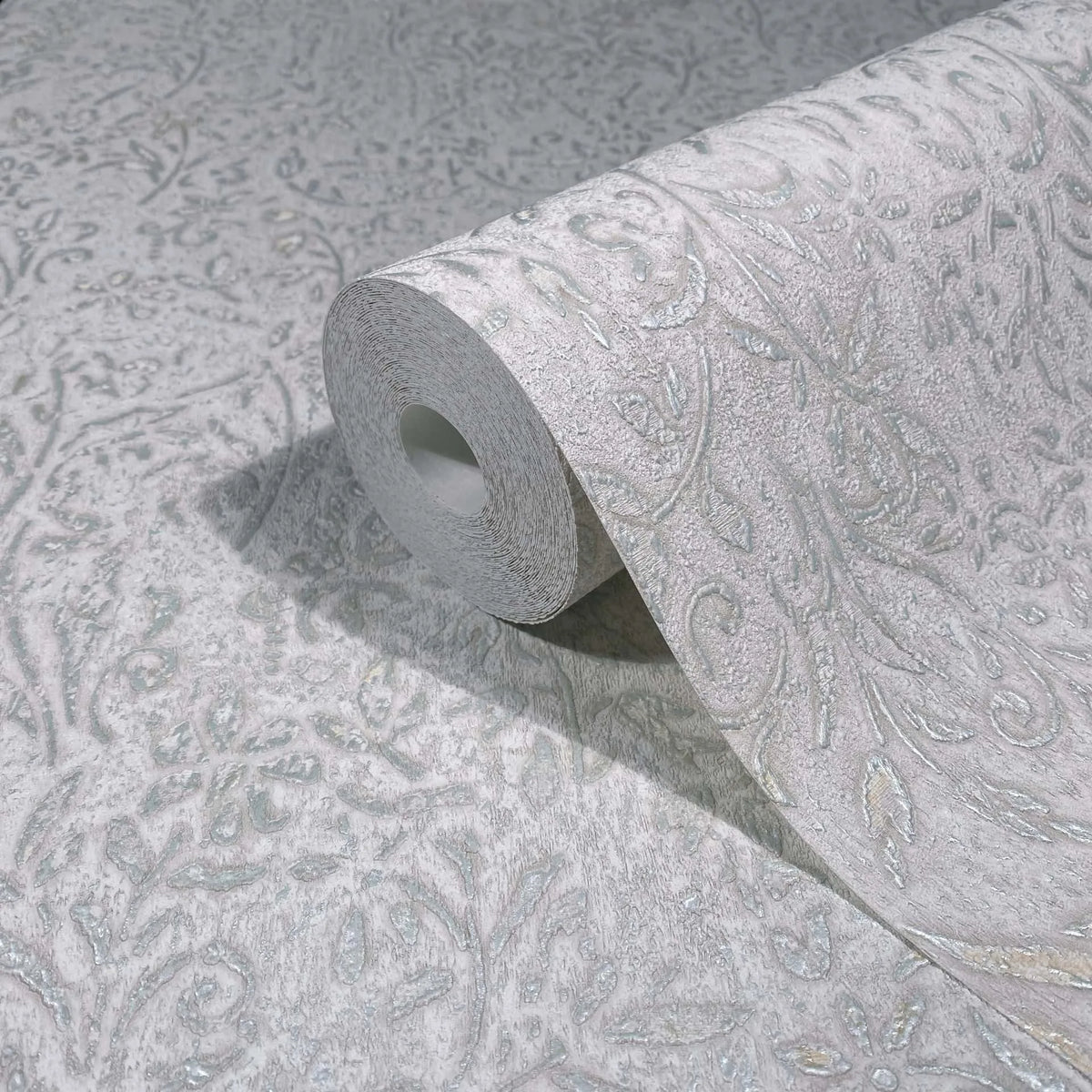Marburg Ritus 35529 Gray wallpaper roll with an embossed floral and vine pattern and subtle metallic sheen, resting on a matching unrolled sheet.