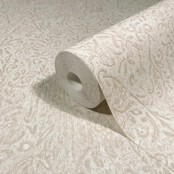 Marburg Ritus 35531 Beige wallpaper roll with a raised ornamental scroll pattern, partially unrolled across a matching surface.