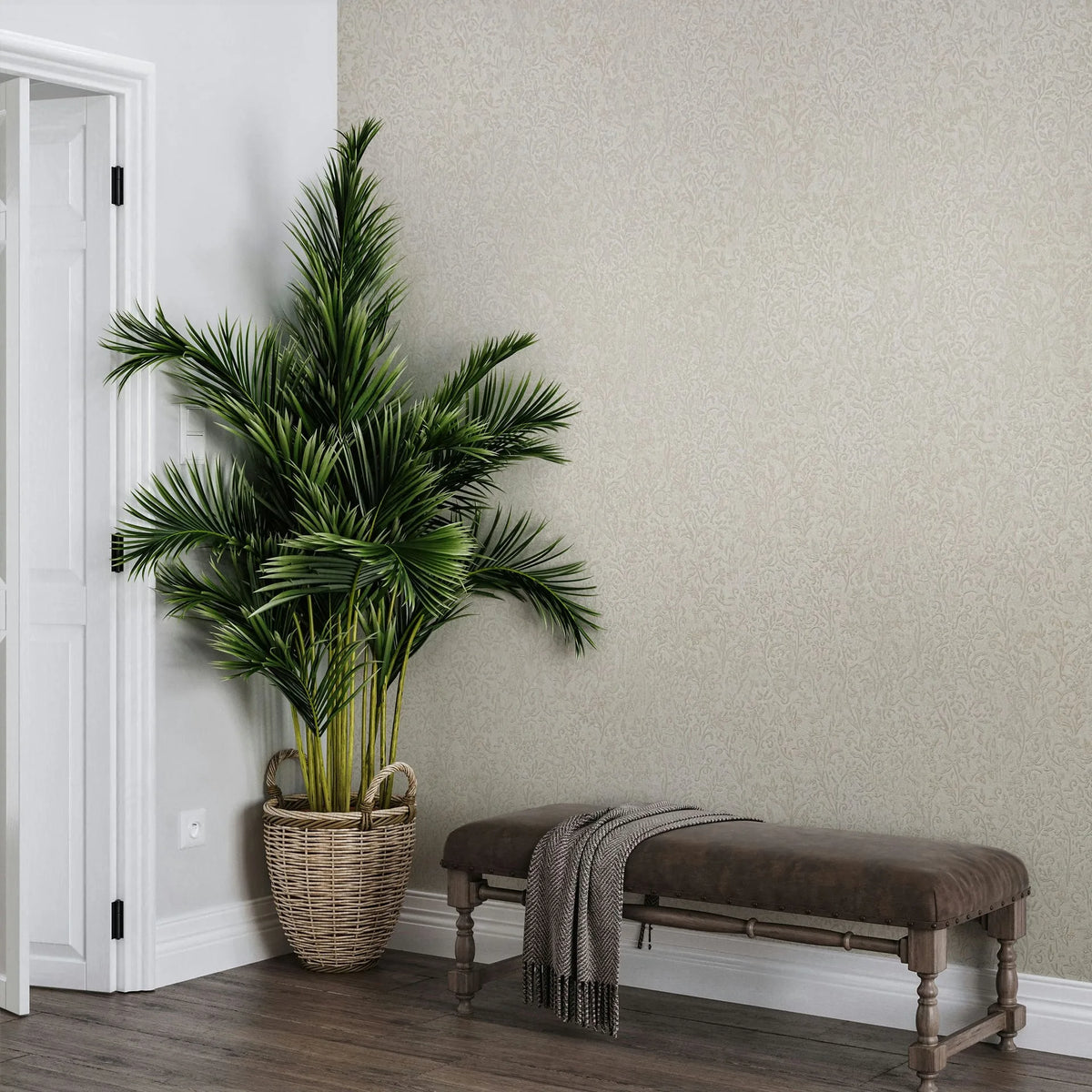 Marburg Ritus 35531 Beige wallpaper with a delicate tonal leaf-and-vine pattern, shown with a potted palm in a woven basket next to a bench with a draped throw.