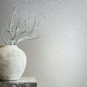 Marburg Ritus 35536 Light gray wallpaper with a small diamond lattice pattern; a large rough-textured vase with bare branches sits on a stone pedestal at the left.