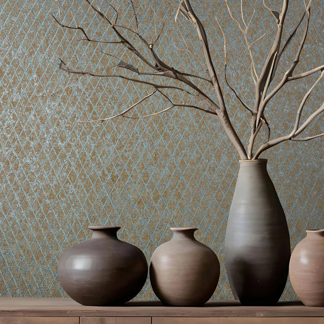 Marburg Ritus 35539 Blue diamond lattice wallpaper on a brown background behind three ceramic vases on a wooden cabinet, with one vase holding bare branches.