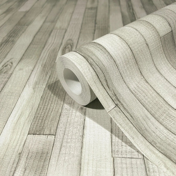 Marburg Struktura 45735 Close-up of a wallpaper roll on a matching surface showing a light gray faux wood plank design with grain and plank lines.