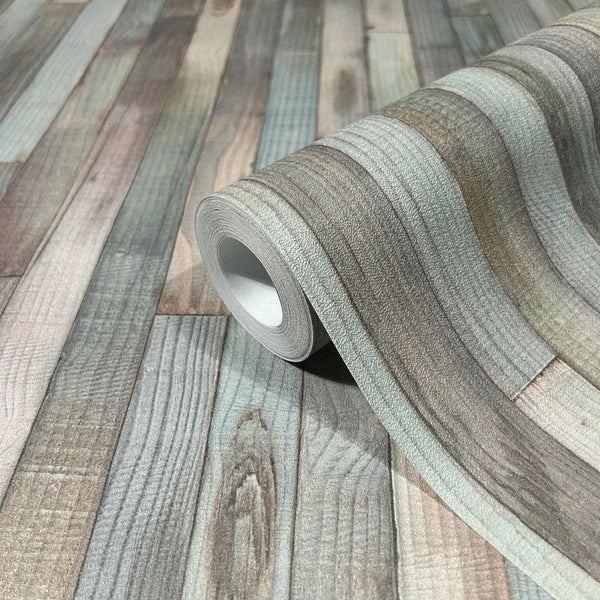 Marburg Struktura 45736 Close-up of a wallpaper roll resting on the same design, showing a faux wood plank pattern in gray, beige, brown, and turquoise shades.