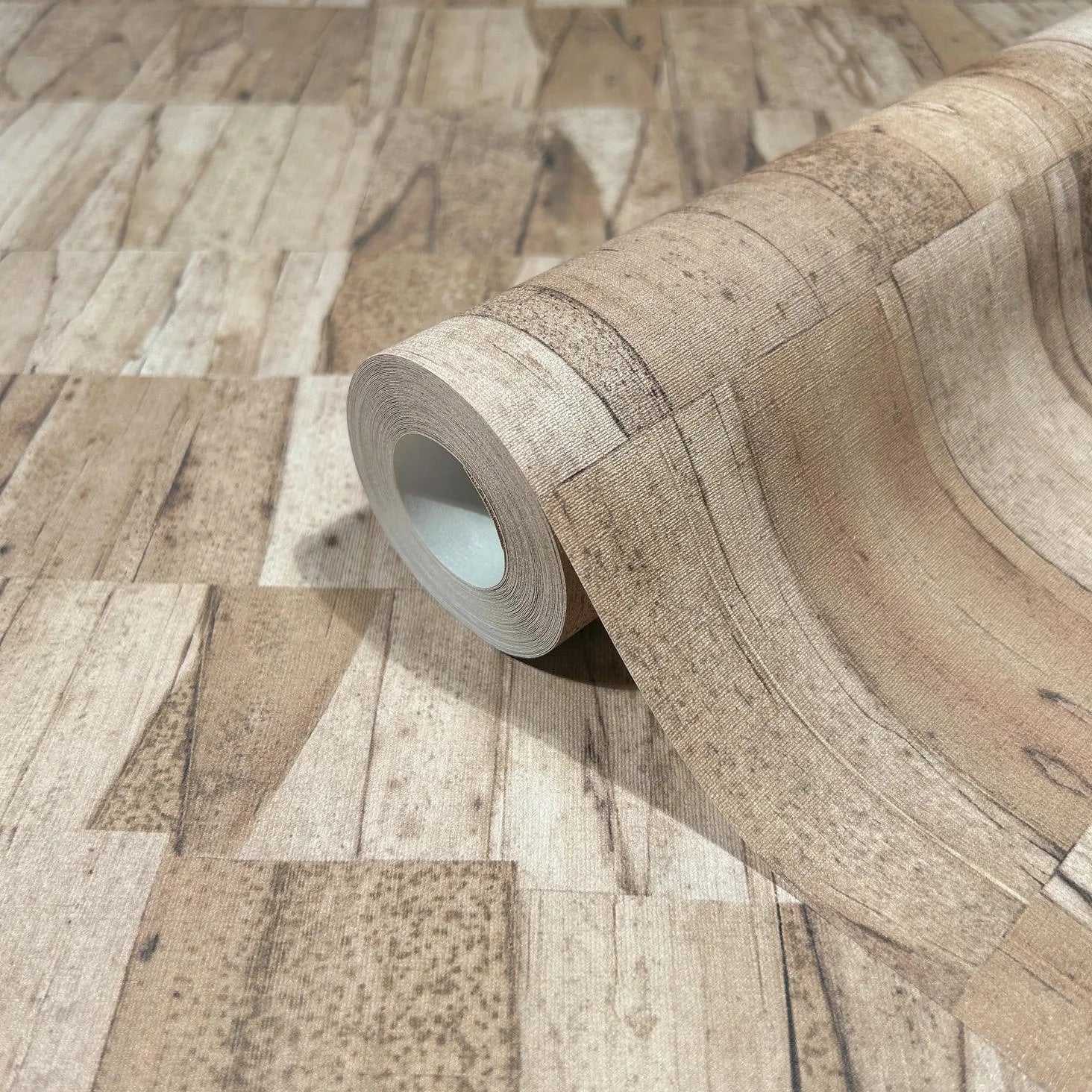 Marburg Struktura 45738 A roll of wallpaper with a brown wood plank pattern, shown partially unrolled on the same design.