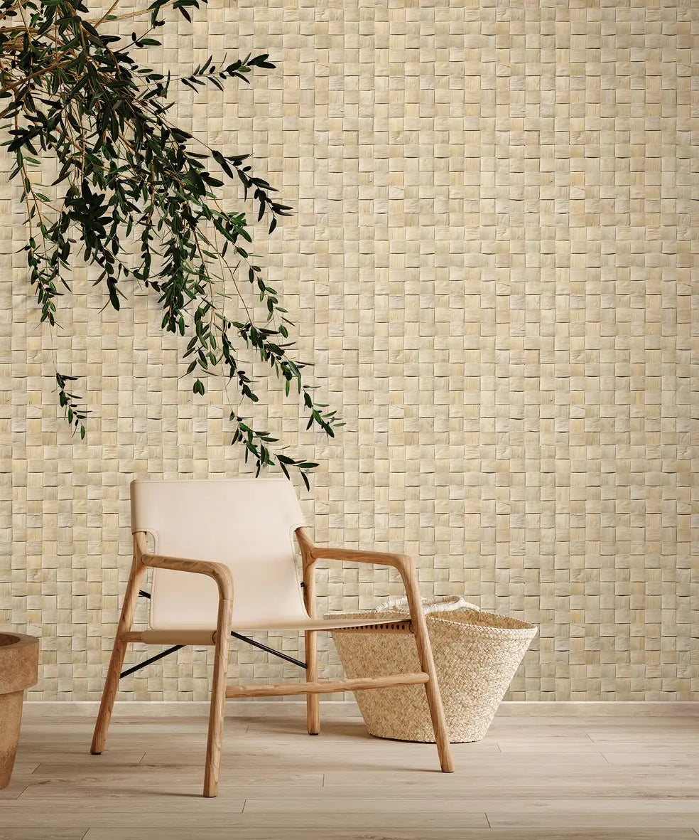 Marburg Struktura 45740 Beige basketweave-pattern wallpaper on a wall behind a light wood chair, a woven floor basket, and a hanging leafy branch over a light wood floor.