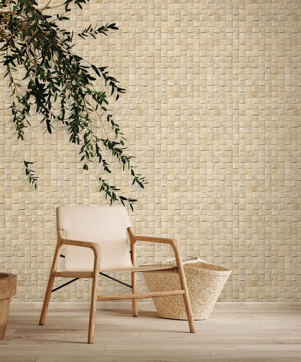 Marburg Struktura 45740 Beige basketweave-pattern wallpaper on a wall behind a light wood chair, a woven floor basket, and a hanging leafy branch over a light wood floor.