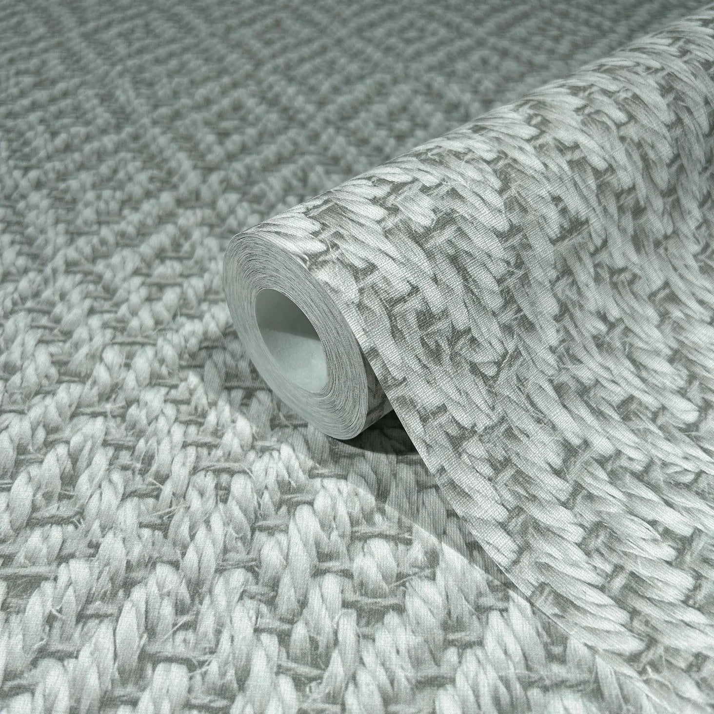 Marburg Struktura 45747 Wallpaper roll resting on a matching unrolled sheet, showing a gray woven braid-style pattern in gray tones.
