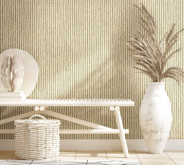 Marburg Struktura 45749 Beige wallpaper with a vertical braided texture behind a light bench; a white wicker basket sits below and a tall white vase with dried grasses stands to the right.