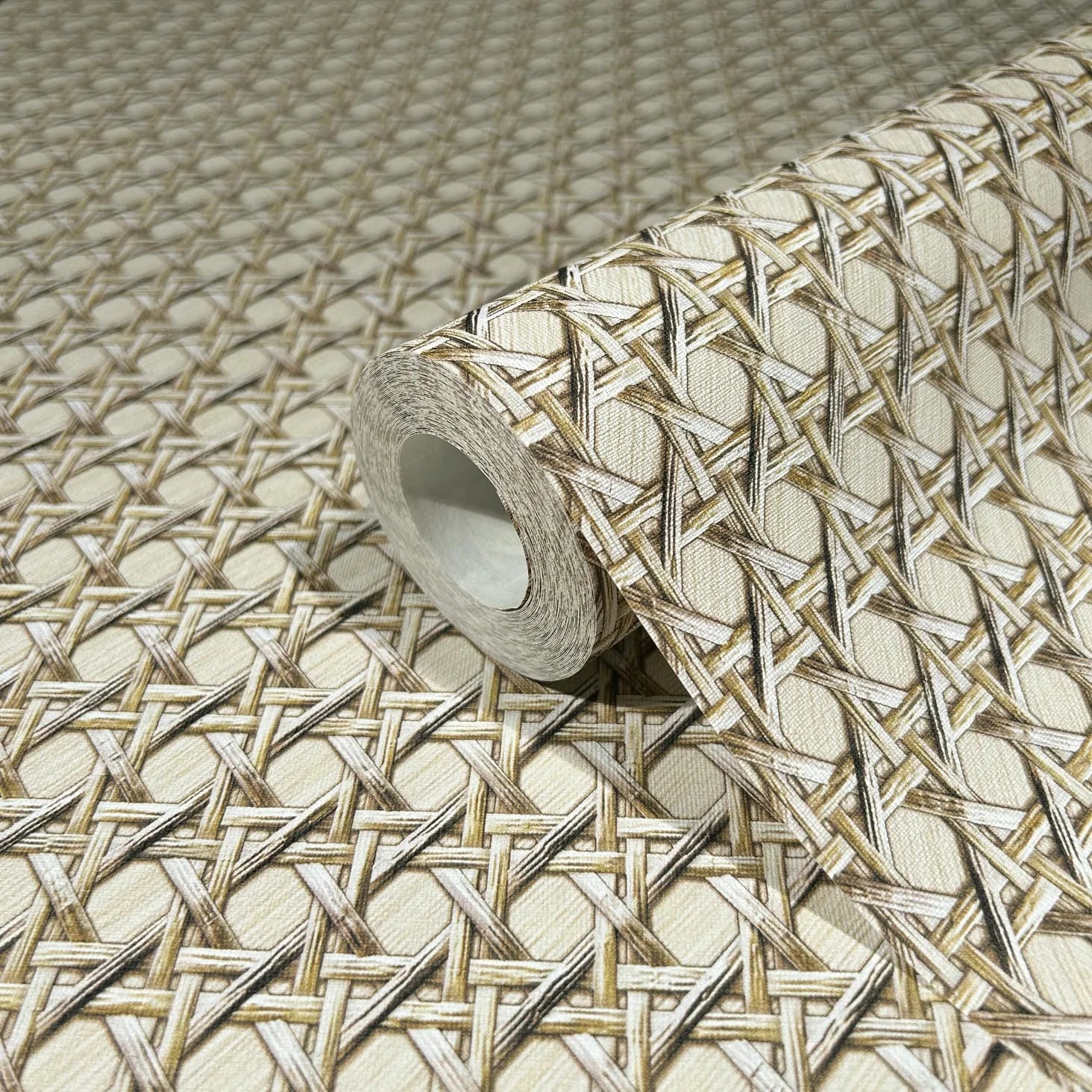 Marburg Struktura 45752 A wallpaper roll resting on matching wallpaper printed with a beige cane-style lattice weave pattern in tan and cream forming a diamond grid.