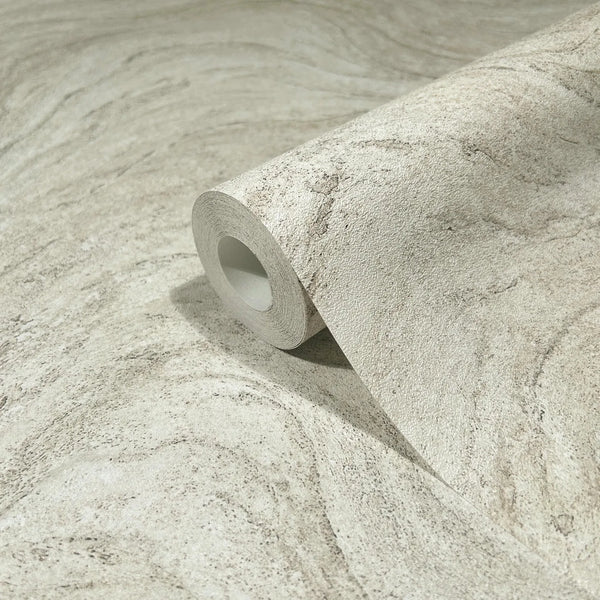 Marburg Struktura 45757 Close-up of a wallpaper roll resting on matching unrolled wallpaper, showing a beige and gray stone-like swirl pattern with fine grain.