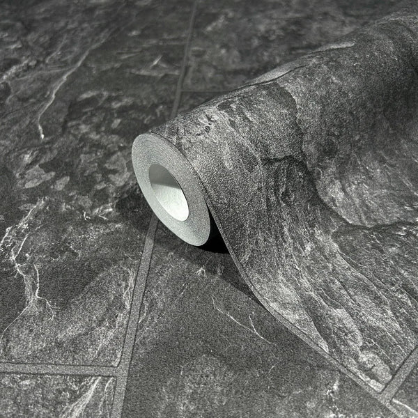 Marburg Struktura 45765 A wallpaper roll on an unrolled sheet showing a dark anthracite stone tile effect with veined slate texture and grout lines.