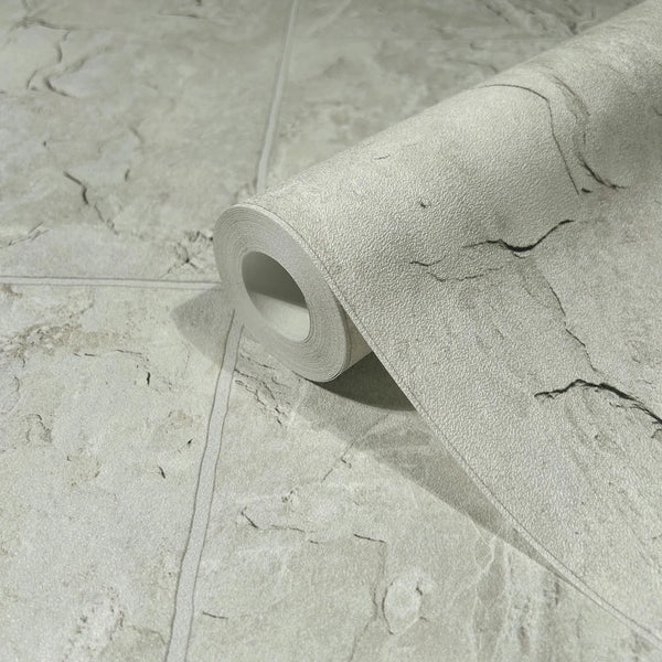 Marburg Struktura 45767 Close-up of a gray stone-look wallpaper roll resting on a matching unrolled sheet, showing subtle veining and faint block seam lines.
