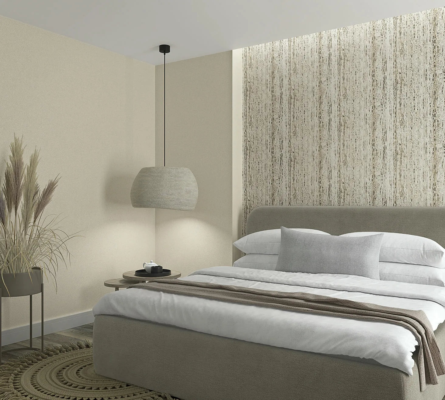 Marburg Travertino 33351 Bedroom scene featuring a vertical beige and taupe streaked wallpaper used as a feature wall behind the bed, with a coordinating solid light‑beige wall to the side. In front are an upholstered bed with white bedding and a gray pillow, a hanging pendant light,a.