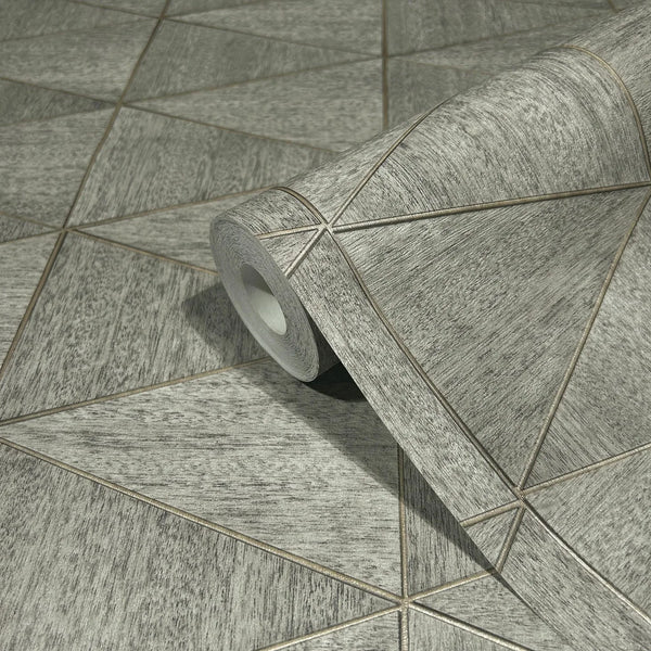 Marburg Travertino 33355 Close-up of a gray geometric wallpaper roll with thin diagonal lines forming triangles, resting on the same patterned surface.