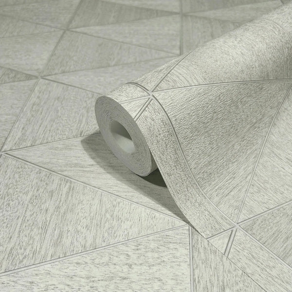 Marburg Travertino 33357 Close-up of a wallpaper roll resting on matching wallpaper with a light gray-beige geometric triangle pattern and subtle textured look.