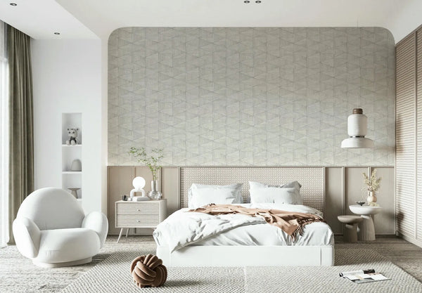 Marburg Travertino 33357 Bedroom scene with a beige‑gray geometric triangle wallpaper on an arched feature wall behind a white bed, accompanied by nightstands, a pendant light, and a rounded armchair.