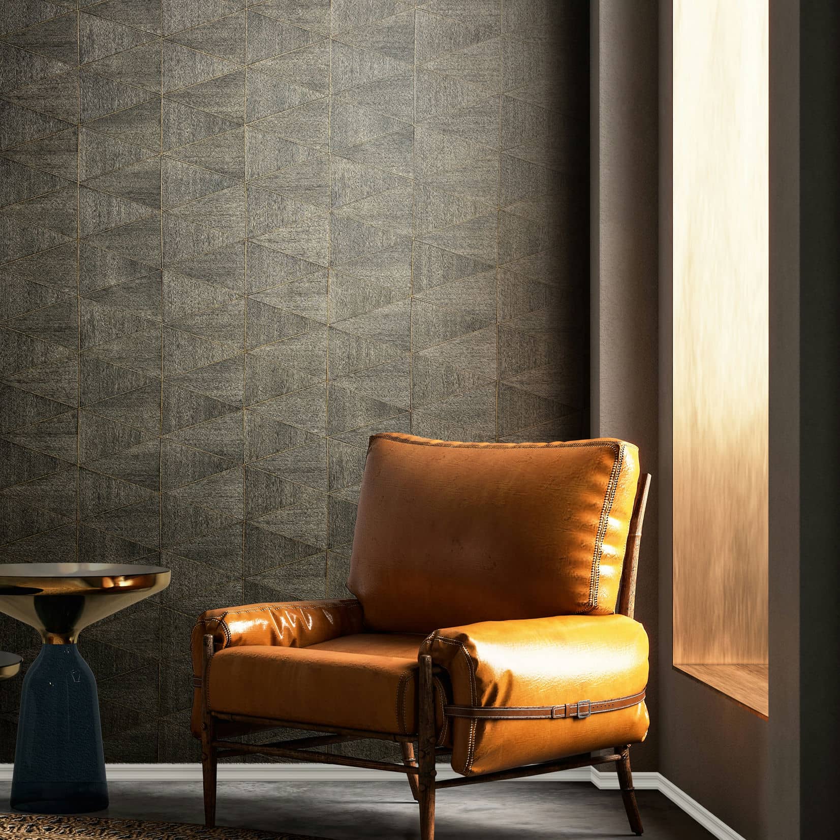Marburg Travertino 33360 Room scene with dark brown geometric wallpaper behind a tan leather armchair, a small side table with a reflective top, and a wall niche casting warm light.