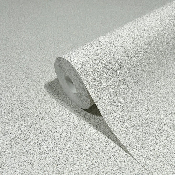 Marburg Travertino 33362 A wallpaper roll with a light gray and beige speckled texture, partially unrolled on a matching surface.