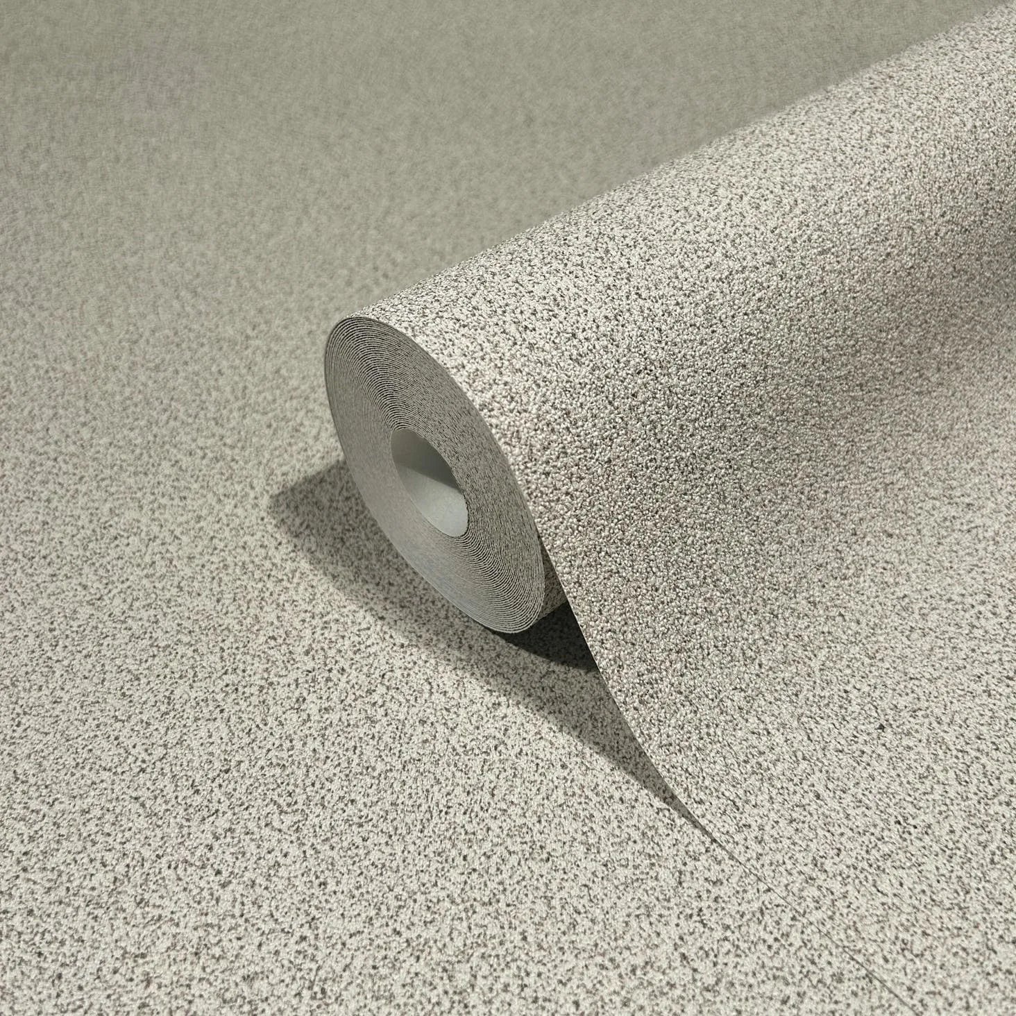 Marburg Travertino 33366 A single roll of light gray speckled wallpaper partially unrolled on a matching surface, showing the fine grain pattern.
