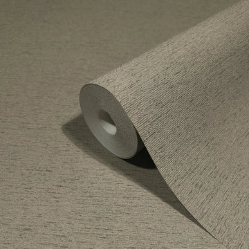 Marburg Travertino 33372 Close-up of a roll of brown textured wallpaper with fine horizontal striations resting on a matching unrolled section.