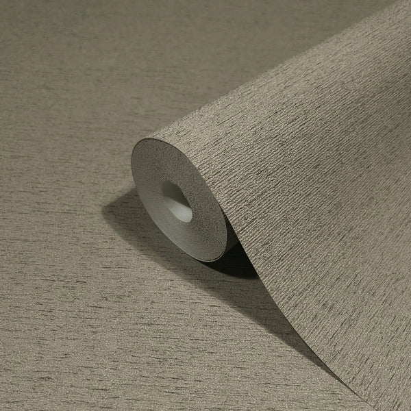 Marburg Travertino 33372 Close-up of a roll of brown textured wallpaper with fine horizontal striations resting on a matching unrolled section.