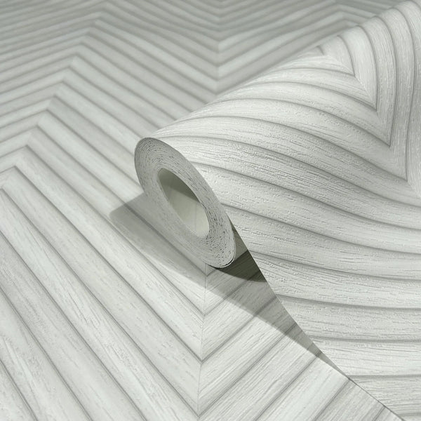 Marburg Travertino 33375 Close-up of a wallpaper roll resting on matching wallpaper showing a light gray and white chevron pattern with fine linear texture.