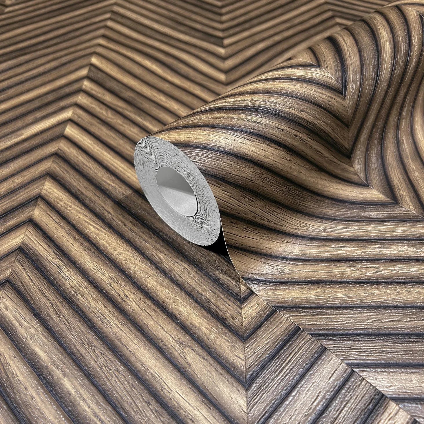 Marburg Travertino 33378 Close-up of a partially unrolled wallpaper roll on matching wallpaper showing a brown woodgrain-look chevron pattern with narrow diagonal ribs.