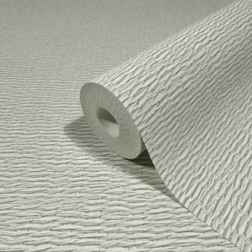 Marburg Travertino 33382 Close-up of a wallpaper roll with raised, wavy linear texture in light beige, resting on a matching unrolled sheet.