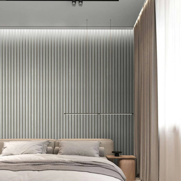 Marburg Travertino 33395 Bedroom scene featuring a silver vertical ribbed wallpaper behind a low upholstered bed, with a slim horizontal light above the headboard, a wood bedside table, and floor-length curtains.