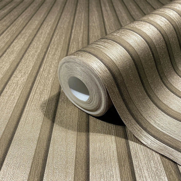 Marburg Travertino 33396 Close-up of a wallpaper roll resting on matching unrolled wallpaper, showing textured metallic gold stripes in alternating widths.