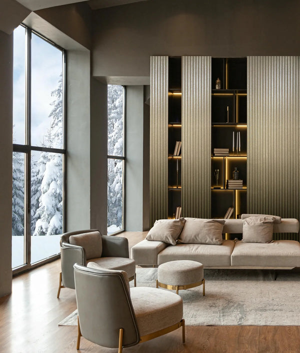 Marburg Travertino 33396 Living room scene showing vertical ribbed gold wallpaper on a wall with open shelving, next to tall windows with snowy trees outside, with a sofa, armchairs, ottomans, and a rug in view.
