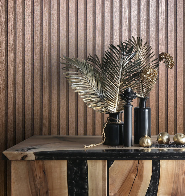 Marburg Travertino 33397 Vertical ribbed textured wallpaper in metallic copper behind a wood console styled with black vases, metal leaf stems, and small gold ornaments.