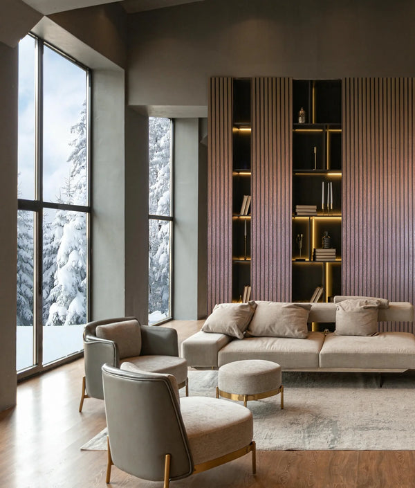Marburg Travertino 33397 Contemporary living room featuring a feature wall clad in warm copper-toned vertical striped wallpaper around illuminated built-in shelves. A neutral sofa with cushions, two armchairs, ottomans, a rug, wood flooring, and tall windows with snowy trees outside.