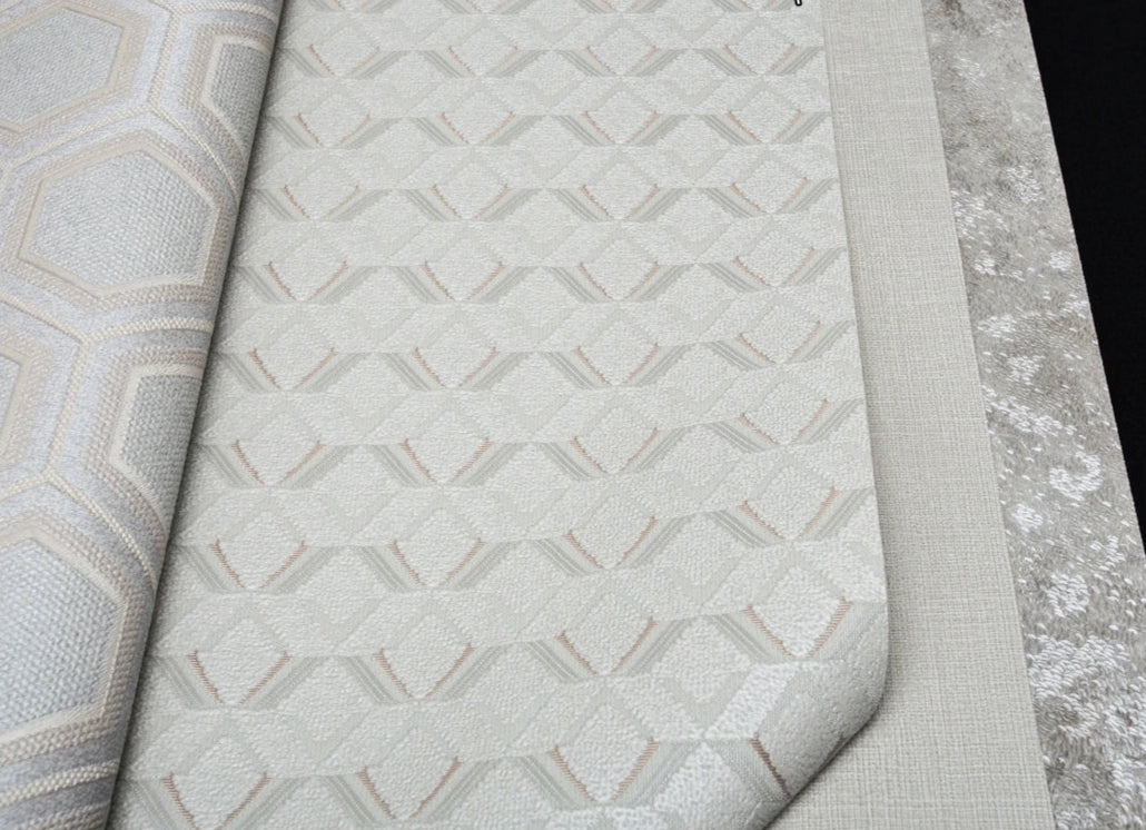 Close-up of textured wallpaper with geometric pattern on a gray surface.