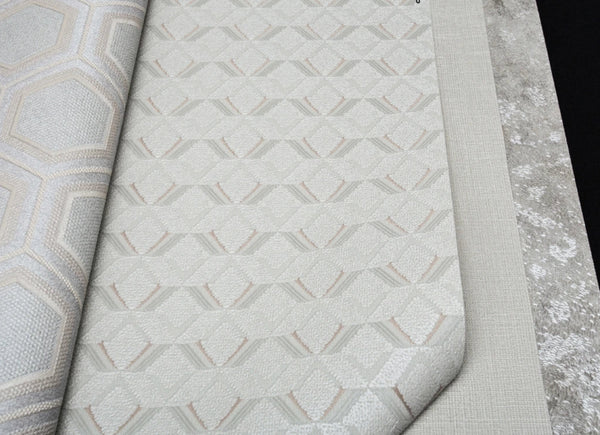 Close-up of textured wallpaper with geometric pattern on a gray surface.