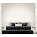 Bedroom with a black bed and white bedding against a geometric patterned wall.