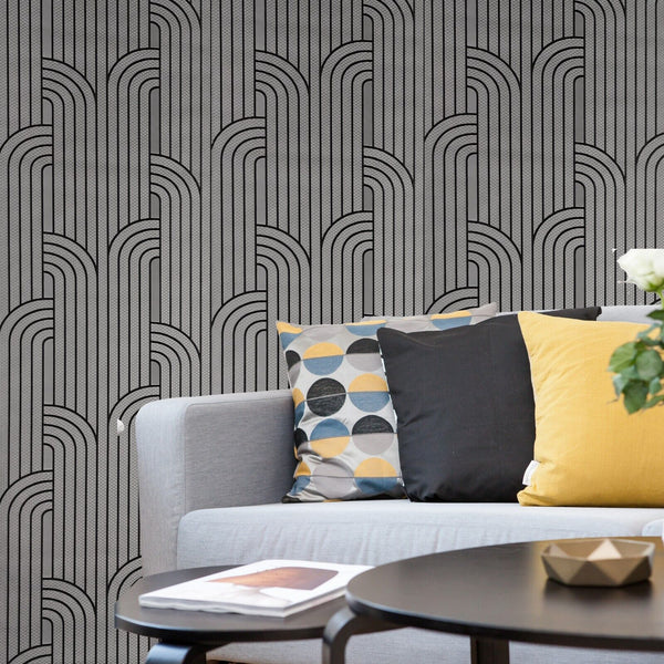 Gray sofa with colorful pillows against a patterned wall.